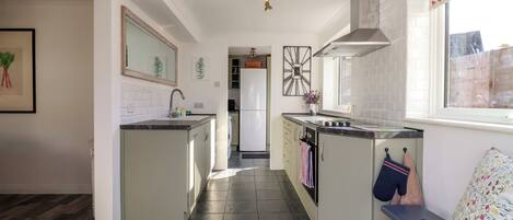 A modern kitchen with a central island, a built-in oven, and a window with a view.