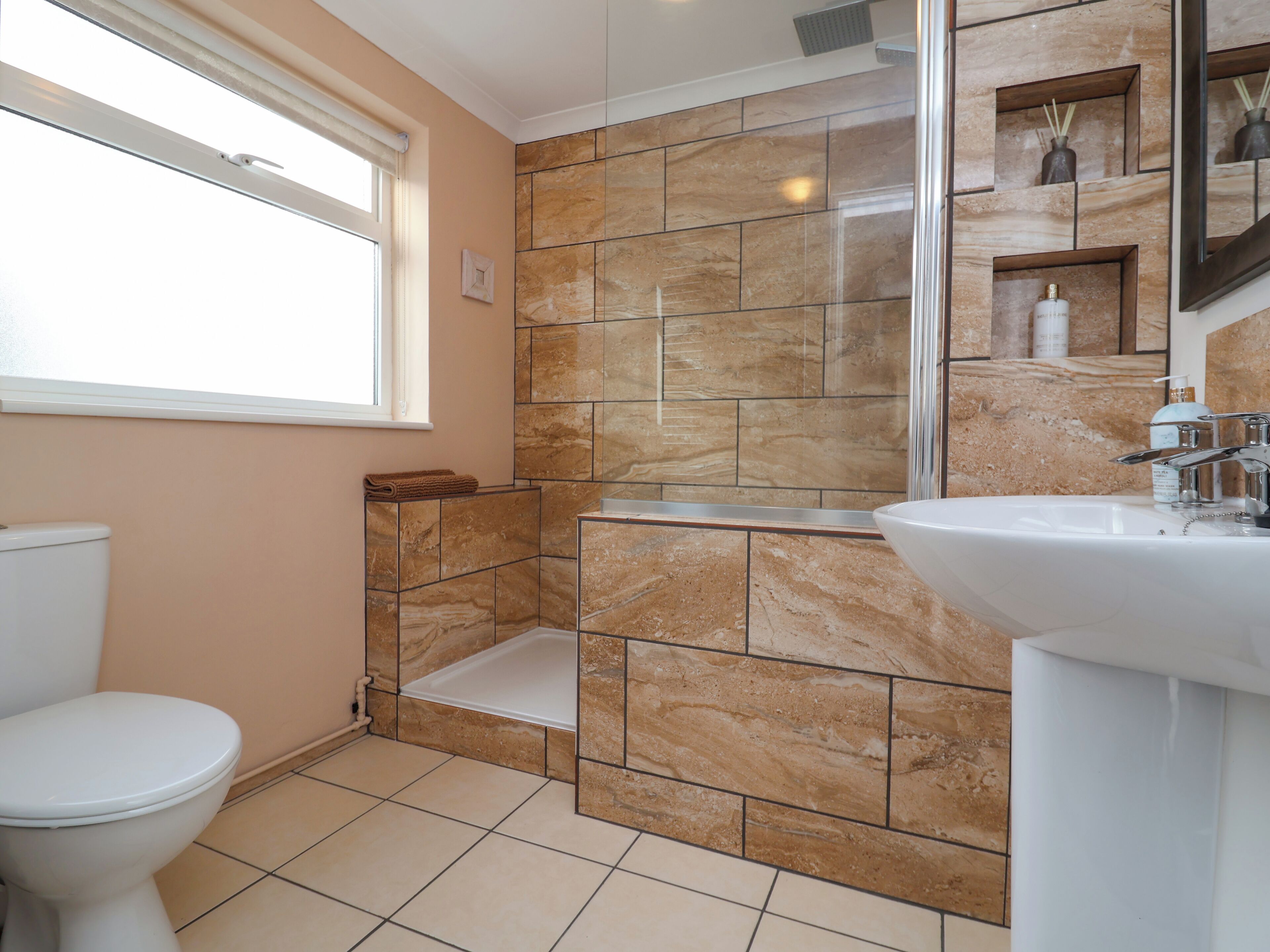 A bathroom with a toilet, a shower, and a sink.