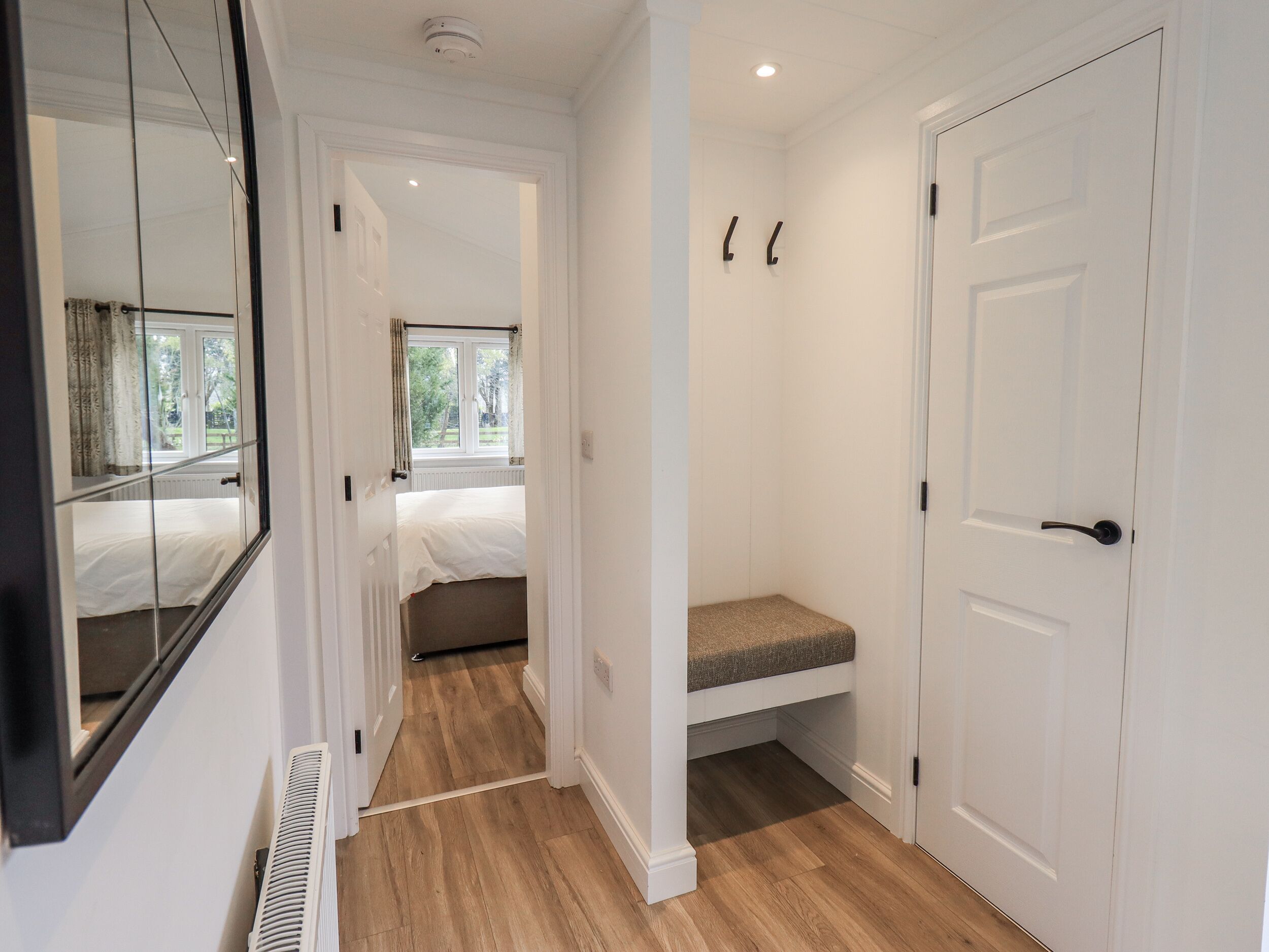 A bedroom with a bed, a window, and a door.