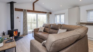 A cozy living room with a sofa, a fireplace, and a view of the outdoors.