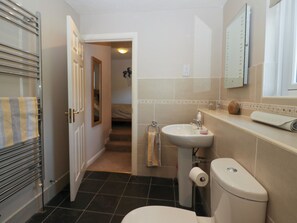 Ein Badezimmer mit Toilette, Waschbecken und Handtuchhalter.