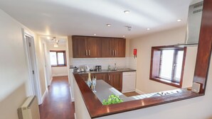 Uma cozinha moderna com armários de madeira, uma ilha integrada e uma máquina de lavar louça.