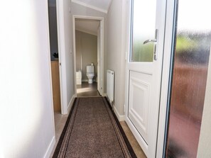 Corridoio che conduce a un bagno con il water e termosifone.