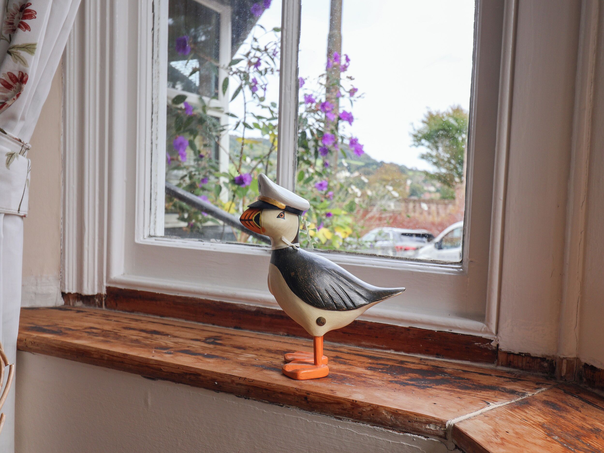 Una figurita de pájaro en un alféizar.