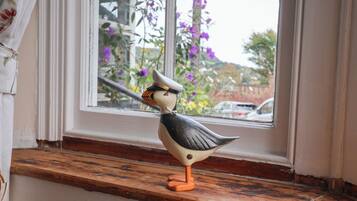 Una figurita de pájaro en un alféizar.