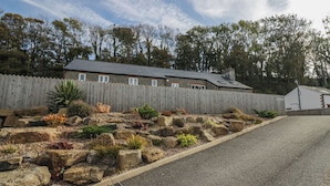 A house with a stone facade, a wooden fence, and a gravel driveway. - Edgemere Retreat (Grange-over-Sands)