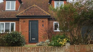 A two-story house with a tiled roof, a brick facade, and a black front door. - 8 Sea Way (Bognor Regis)