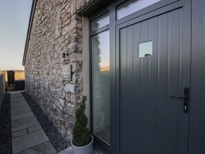 A stone building with a grey door and a sign that reads "Apple Tree Barn". - Apple Tree Barn (Dalton-in-Furness)