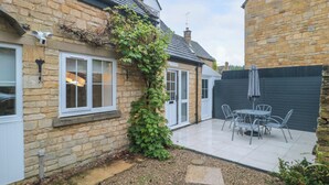 A stone house with a patio and outdoor seating. - 4 Noel Court (Chipping Campden)