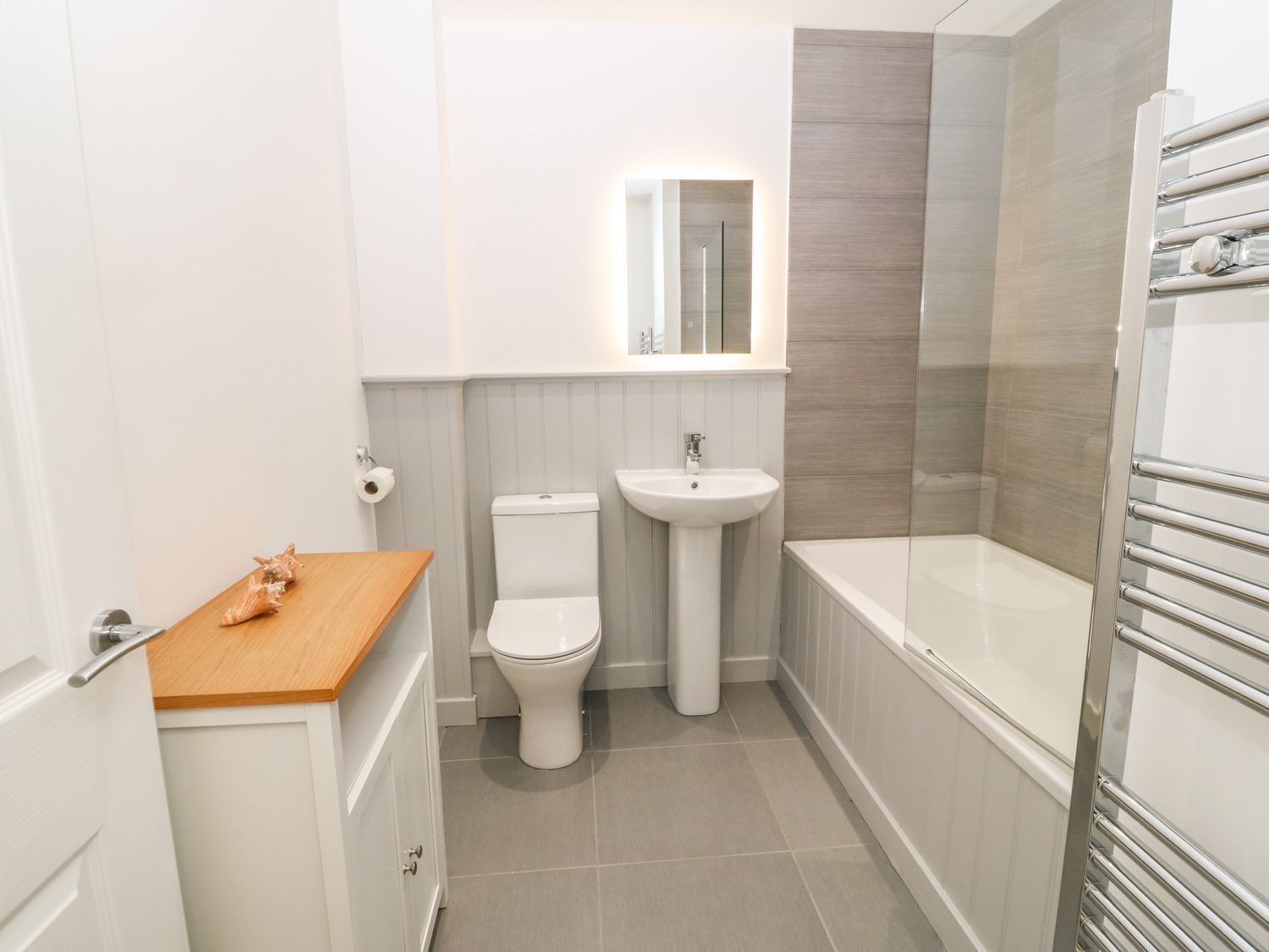 A modern bathroom with a toilet, sink, and bathtub.