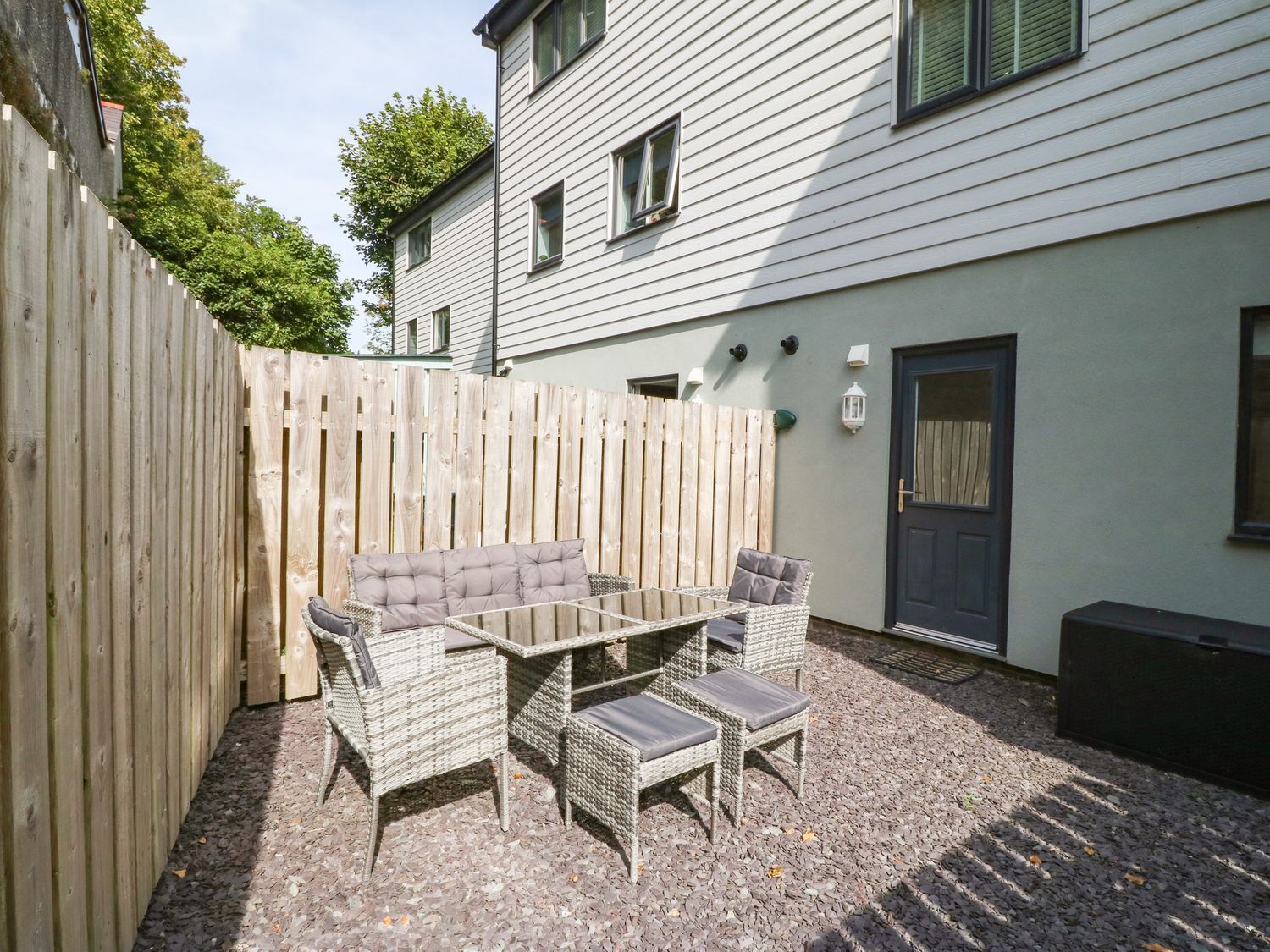 A patio with wicker furniture, a table, and chairs.