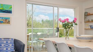 Un coin repas avec une table, des chaises et un vase de fleurs.