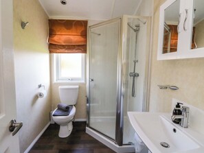 A bathroom with a toilet, a shower enclosure, a sink, and a window. - Crathie Lodge (Fort William)