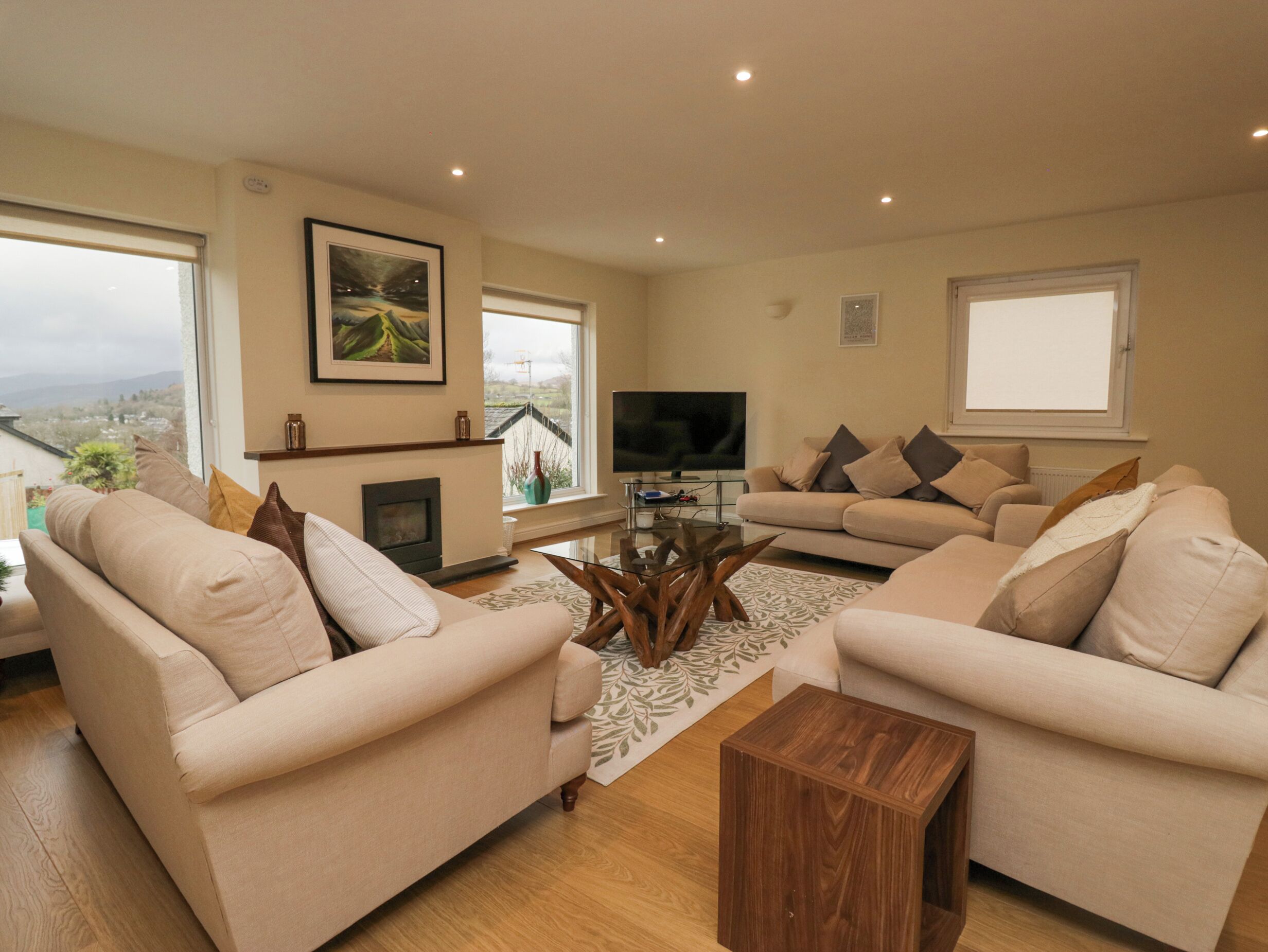 A living room with two sofas, a coffee table, a flat-screen TV, and a fireplace.