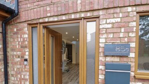 A brick building with a wooden door and a mailbox. - 85A Braybrooke Road (Kettering)