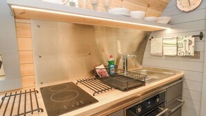 Une cuisine moderne avec un plan de travail en bois, des appareils électroménagers en acier inoxydable et une horloge au mur.