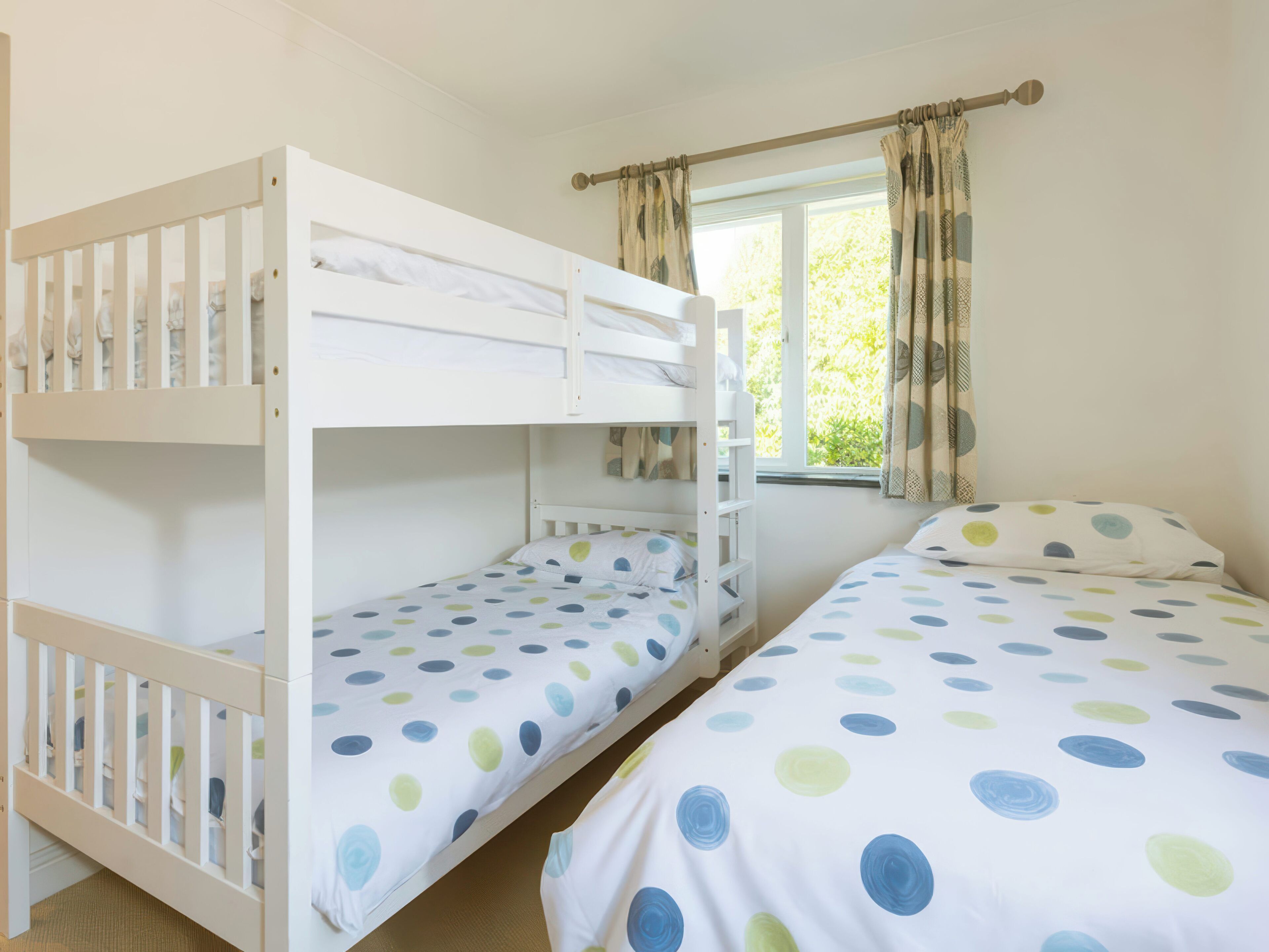 A room with bunk beds and a window with curtains.