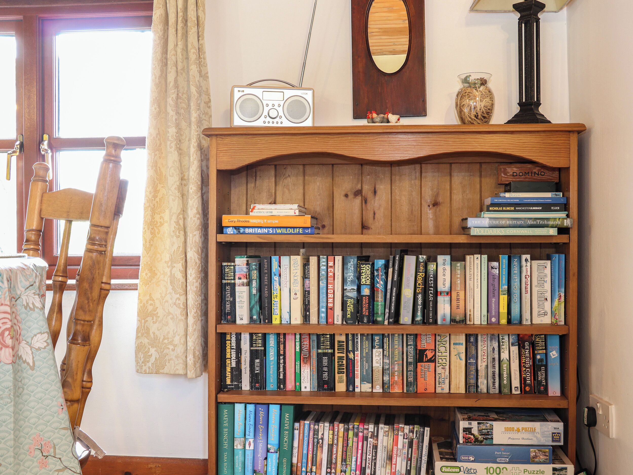 Une bibliothèque en bois remplie de livres et une radio.