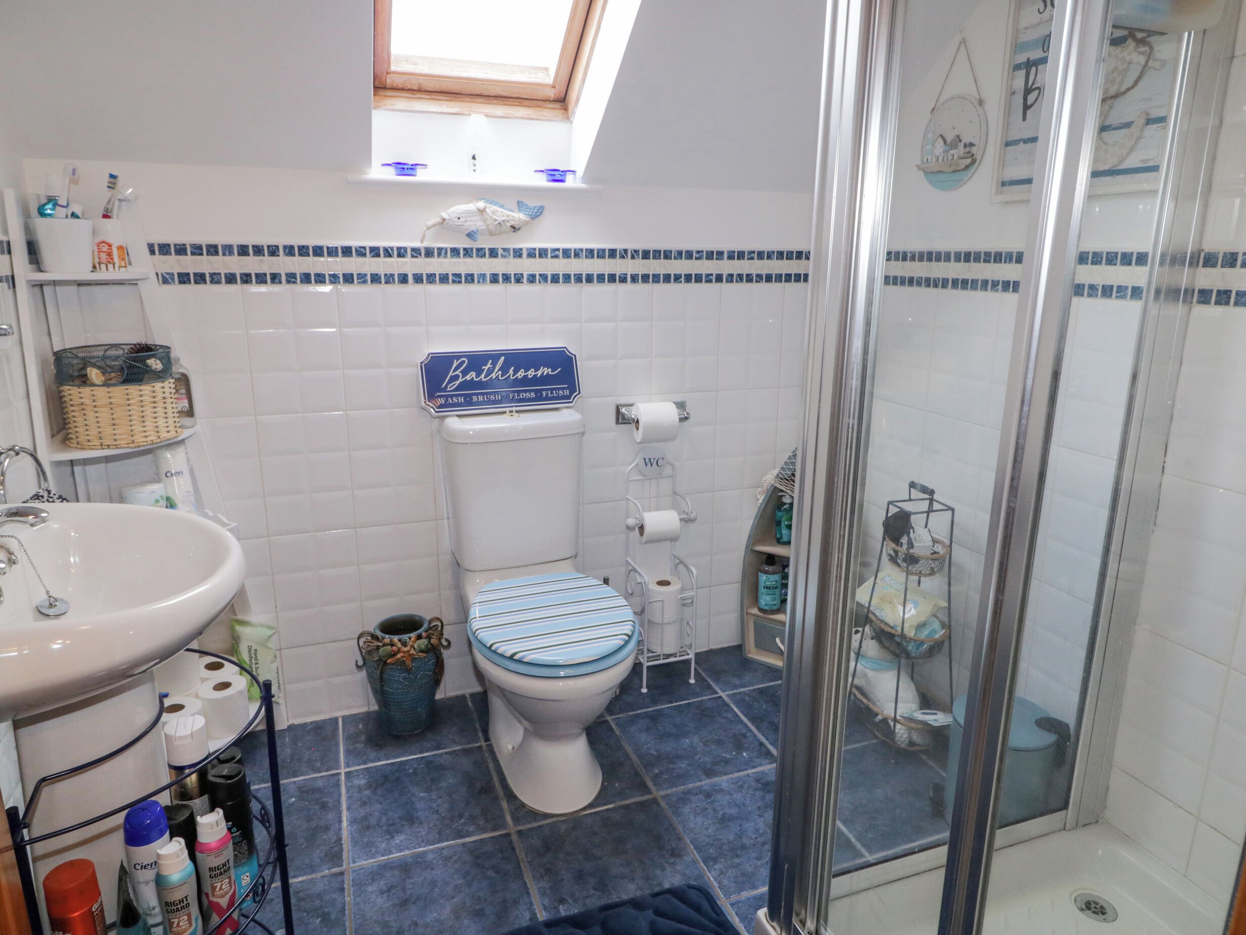 A bathroom with a toilet, sink, and shower.