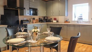 A modern kitchen with a dining area set for six. - The Old Stable (Hull)