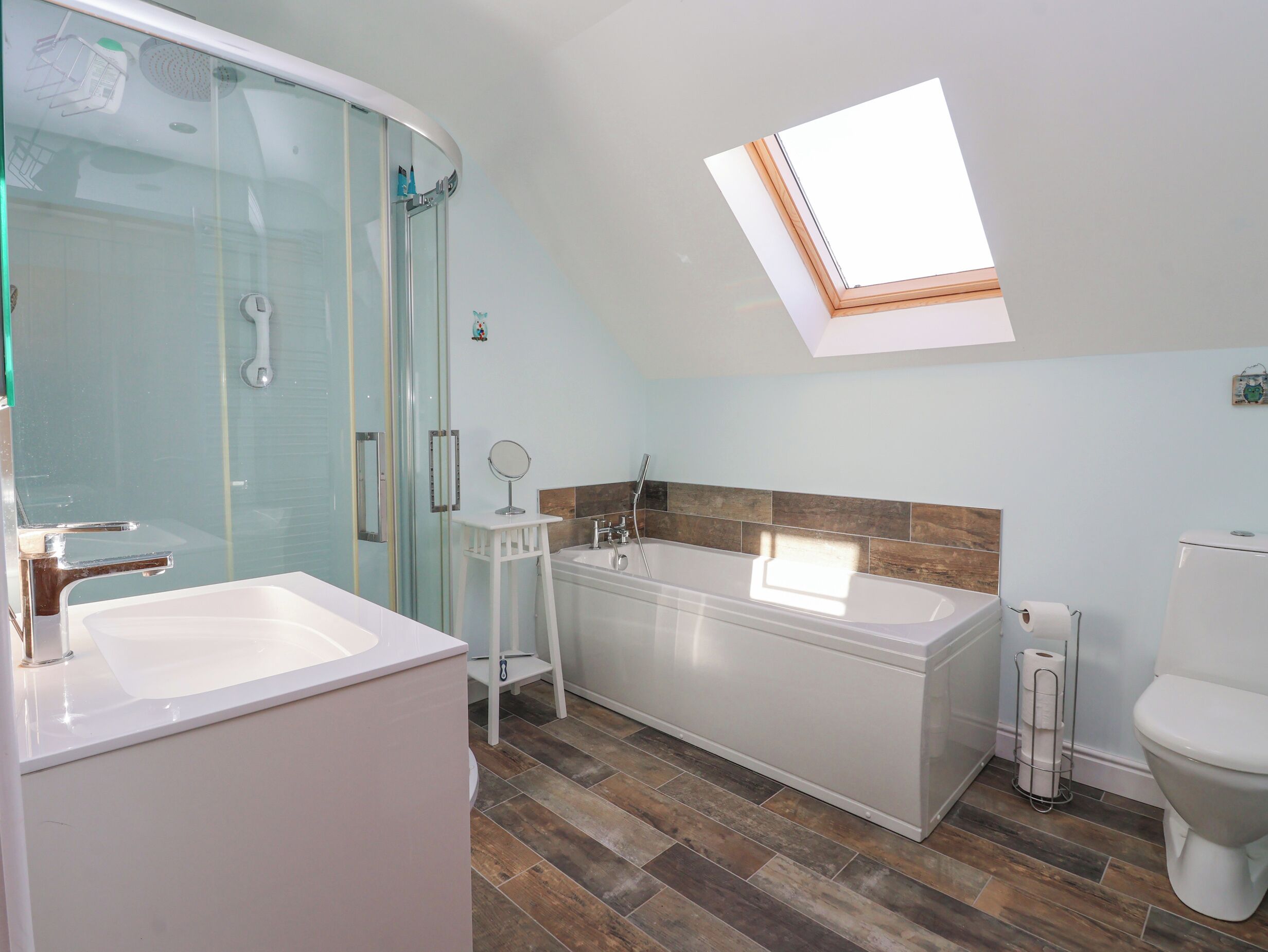 Une salle de bain moderne avec une douche à parois de verre, une baignoire sur pieds et des toilettes.