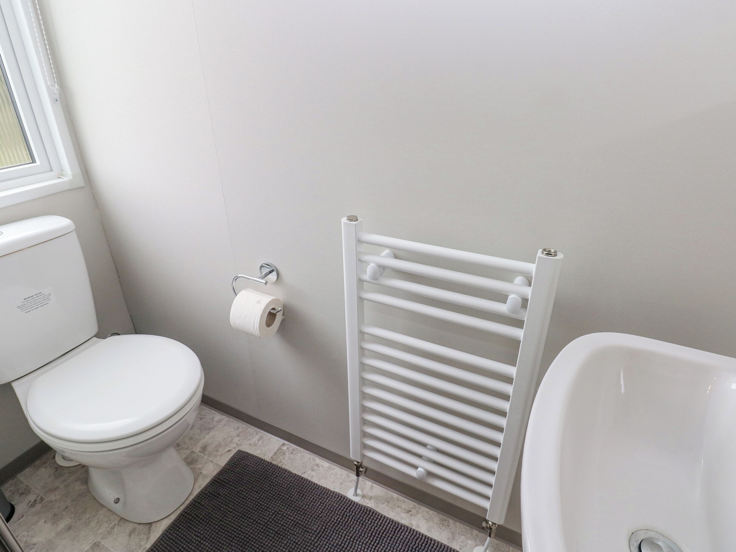 Ein Badezimmer mit Toilette, Handtuchhalter und einer Badewanne.