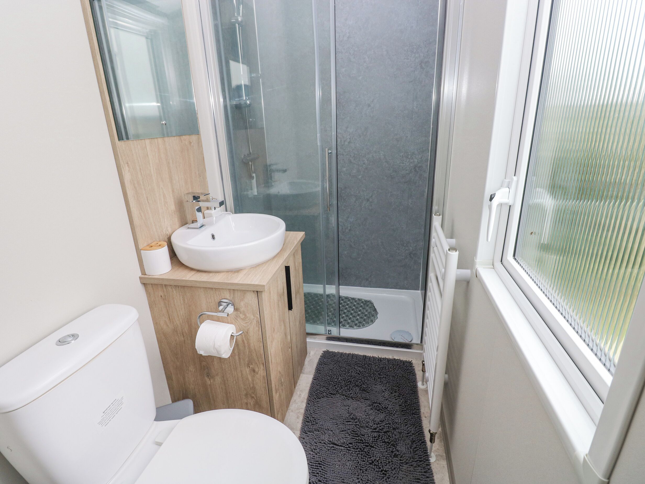 Une salle de bain moderne équipée de toilettes, d’un lavabo et d’une douche.