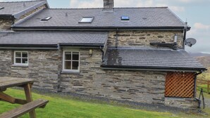 A stone house with a sloped roof, two windows, and a satellite dish. - Ty Llewelyn (Betws-Y-Coed)