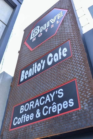 Un letrero de hotel con la inscripción "Benito's Cafe" y "Boracay's Coffee & Crepes".