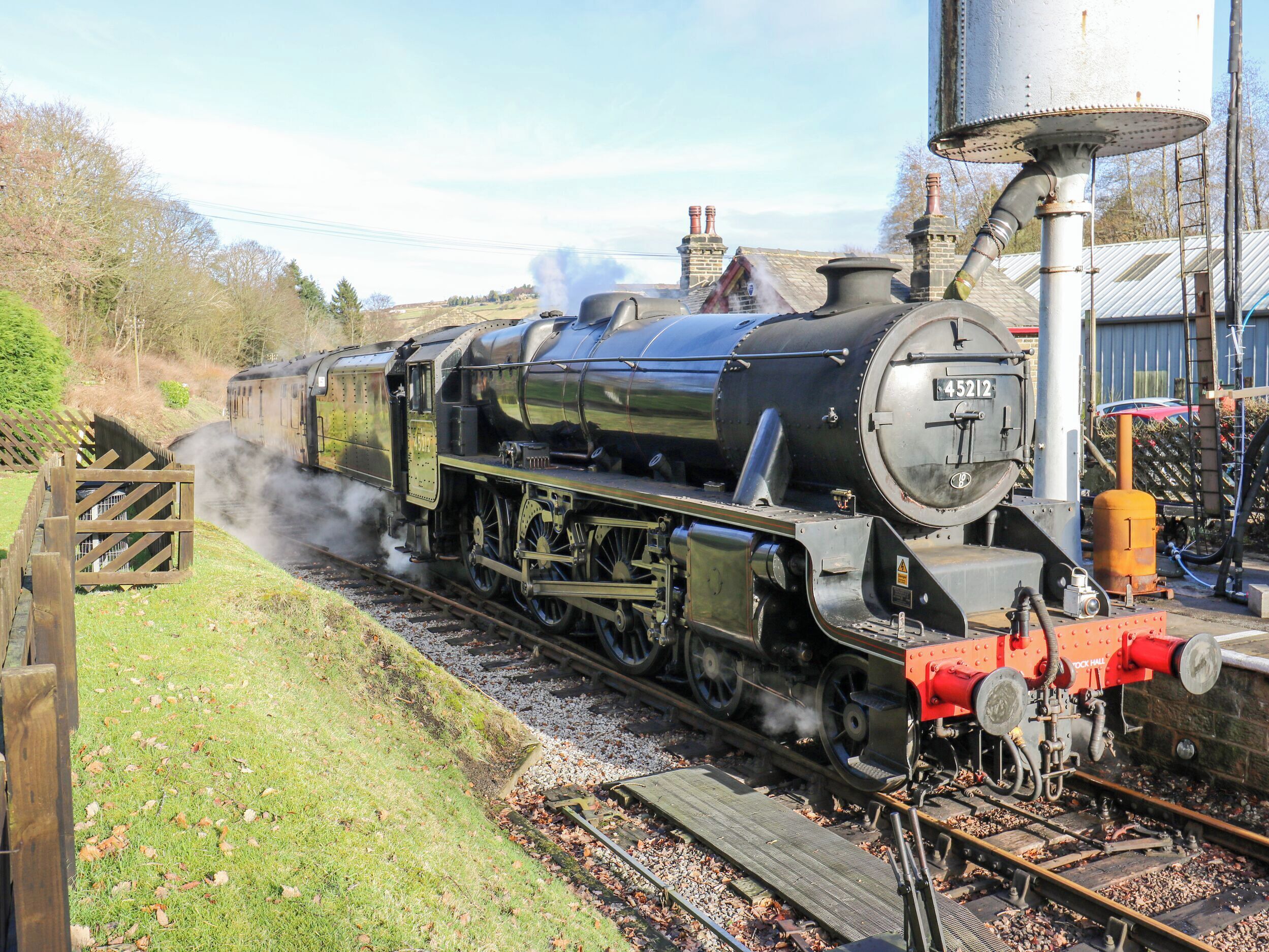 Una locomotora de vapor con el número 45212 sobre una vía de tren.