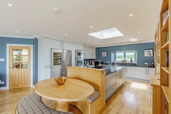 A modern kitchen with white cabinets, a central island, and a skylight. - Balcary Tower (Castle Douglas)