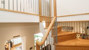 A wooden staircase with metal railings leading to an upper floor. - The Stables (Penzance)