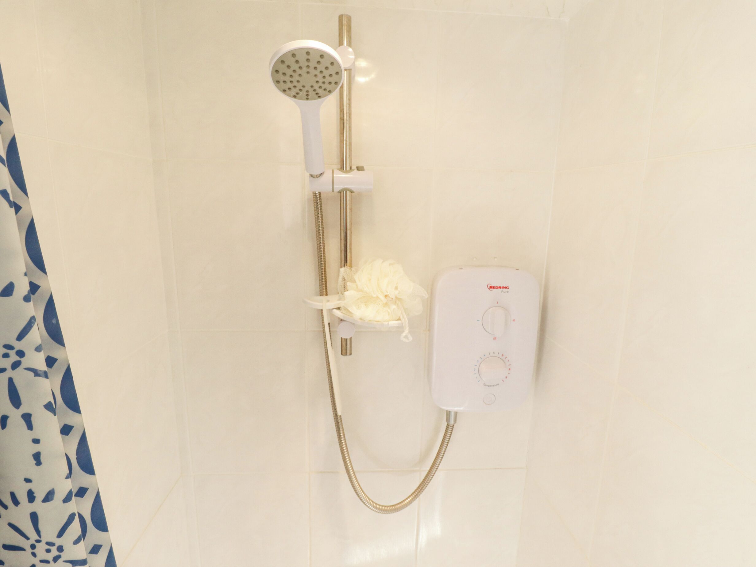 A shower with a handheld showerhead, a handheld shower attachment, and a control panel.
