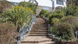 A set of stone steps leading up to a building with a white exterior and a stone facade. - 17 St Elmo Court (Salcombe)