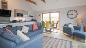 A modern living space with a kitchen, dining area, and seating. - Skye Falls Chalet (Glendale)