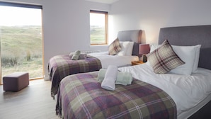 A bedroom with two beds, a large window, and a view of the outdoors. - Skye Falls Chalet (Glendale)