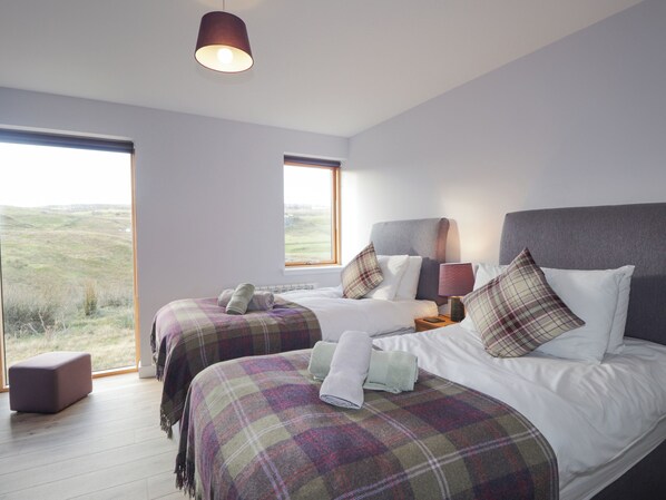 A bedroom with two beds, a large window, and a view of the outdoors. - Skye Falls Chalet (Glendale)