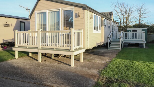 A mobile home with a front deck, large windows, and a number '20' sign. - Seasalt Haven (Chichester)