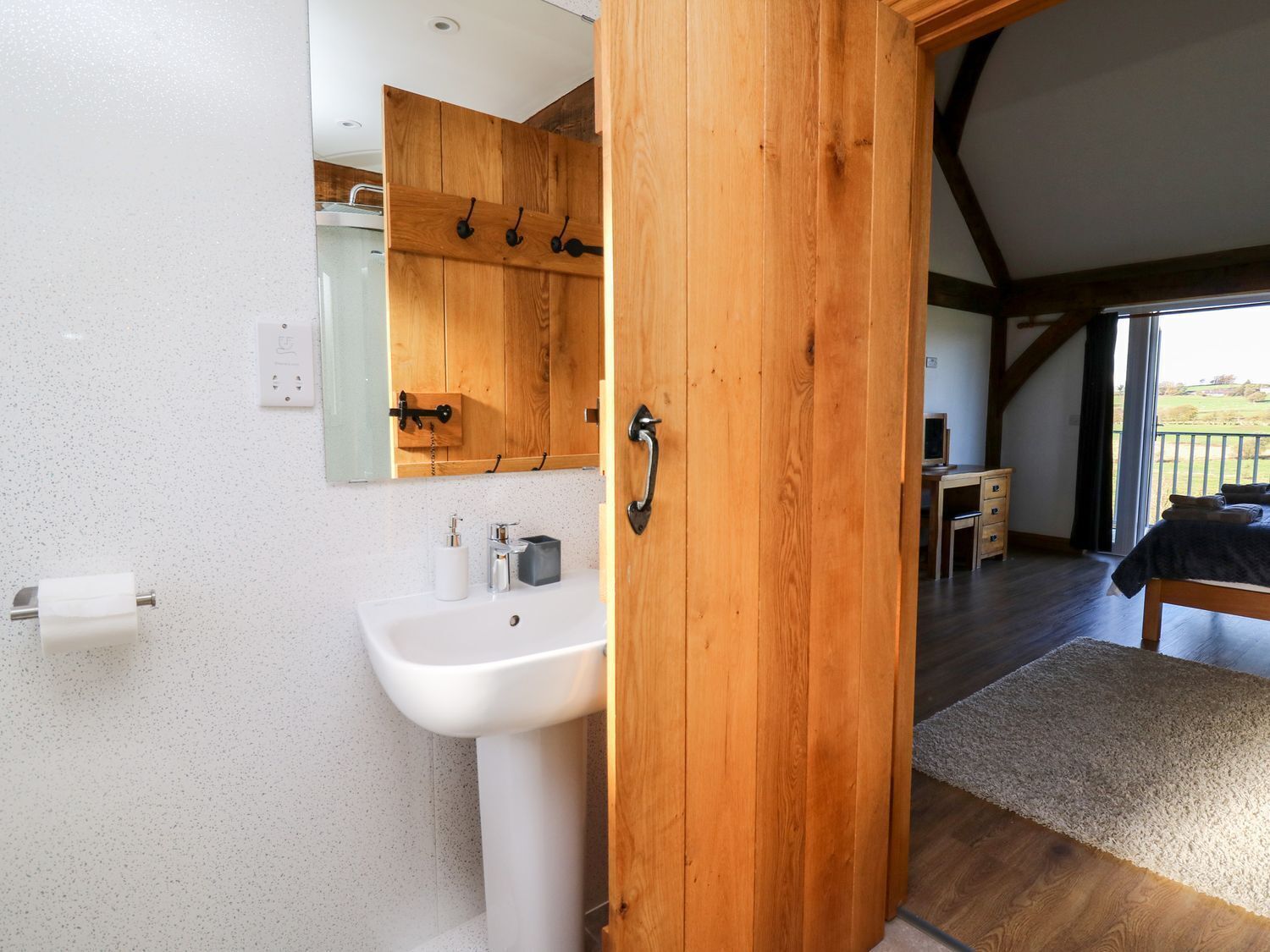 A modern bathroom with a wooden vanity, a sink, and a mirror.