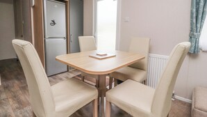 Une cuisine compacte dotée d’un réfrigérateur encastré, d’un meuble en bois et d’une porte blanche.