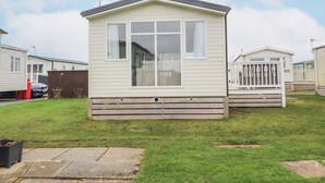 Une petite maison mobile d’un seul étage, dotée d’un porche à l’avant et d’une grande fenêtre.