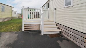 Une maison mobile avec un escalier en bois menant à une terrasse.