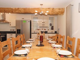 Un comedor con una mesa de madera dispuesta para seis personas, rodeada de sillas de madera.