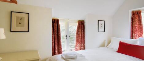 Una camera da letto con un letto, una cassettiera e due quadri appesi al muro.