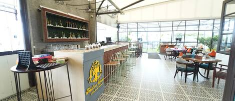 Un restaurante con barra, asientos y vistas amplias a través de grandes ventanales.