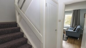 A staircase leading to a landing with a closed door. - Kittiwake, Apartment 22 (Haverfordwest)