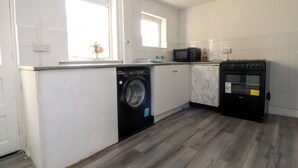 Μια κουζίνα με πλυντήριο ρούχων, φούρνο μικροκυμάτων και φούρνο.