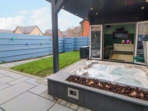 A hot tub with a fire feature, a covered patio area, and a view of a house in the background. - 4 Rockcliffe Grange (Mansfield)