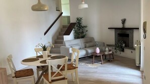 A modern living room with a dining area, a staircase, and a fireplace. - LAKE AND MOUNTAIN (Civenna)