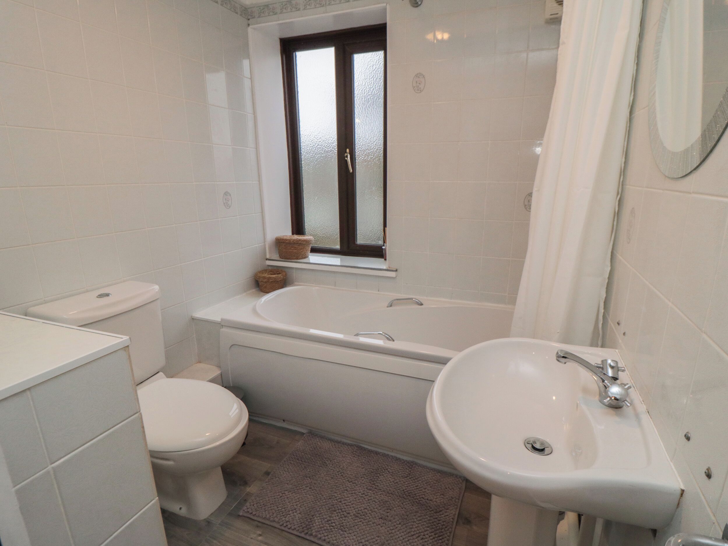 A bathroom with a toilet, sink, and bathtub.